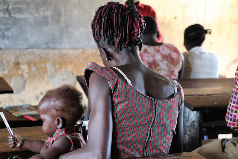 Woman with baby at a desktop learning